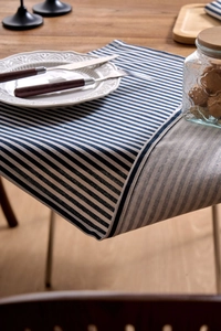 Close-up of blue and white striped Japanese linen napkin on a rustic wooden dining table