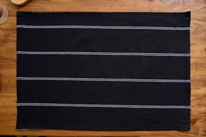 Macro shot of Nordic style black and white striped cotton napkin on wooden table