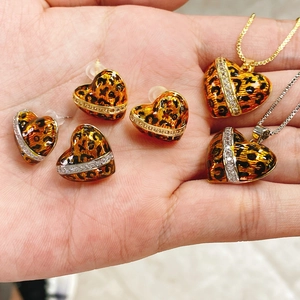 Detalle de pendientes de corazón con estampado de leopardo y collares con cristales