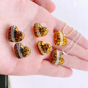 Primer plano de conjunto de joyas corazón de leopardo con diamantes de imitación