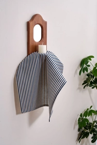 Close-up of blue and white striped cotton-linen napkin hanging in a minimalist setting