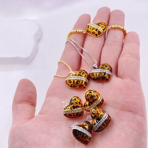Detalle macro del set de joyas corazón en esmalte de leopardo con pavé de circonitas