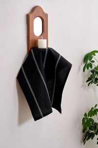 Detail of black and white striped linen napkin hanging on a vintage wooden candle holder