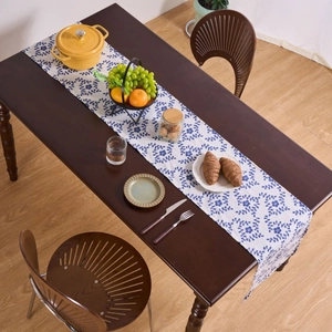 Floral print table runner with blue botanical patterns on a dark wooden dining table
