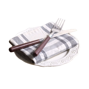 Besteckset aus Edelstahl im europäischen Stil mit grauer Serviette und Relief-Teller