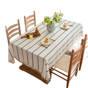 Rectangular cream tablecloth with black vertical stripes and tassel fringe in boho style