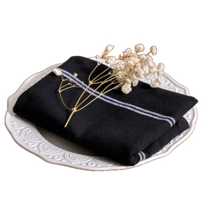 Nordic black and white striped cotton linen dinner napkin folded on a white ceramic plate