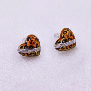 Detalle de pendientes de corazón con estampado de leopardo, cristales y silicona