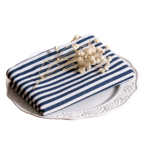 Japanese style blue striped cotton linen napkin placed on a white embossed ceramic plate