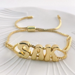 Detail of 18k gold plated SAK letter bracelet with adjustable box chain and slider clasp