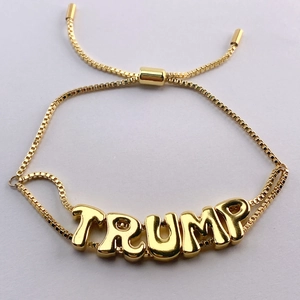Detailed view of adjustable golden box chain bracelet featuring TRUMP letter charms