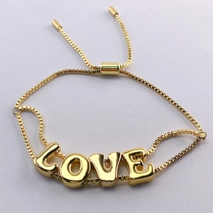 Detail of 18k gold plated LOVE letter charms on a box chain with adjustable slider clasp