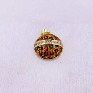 Detalle de pendientes redondos de leopardo con base dorada y banda de diamantes