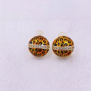 Detalle de pendientes redondos de leopardo con banda dorada y circonitas blancas