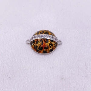 Detalle de pendientes de esmalte con estampado de leopardo, cristales y acabado plateado