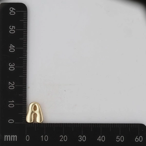 Macro shot of a 10mm gold letter A pendant showing precise measurements on a scale