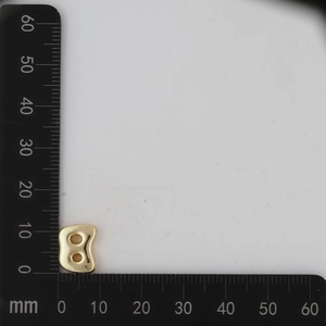 Close-up of a 11mm by 8mm golden letter B pendant with scale measurement on gray background