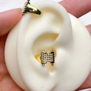 Detailansicht der vergoldeten Ohrmanschette mit Zirkonia an einem Silikon-Ohrmodell