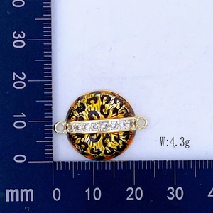 Detalle de pendiente redondo de leopardo en regla de medición con peso de 4,3 g