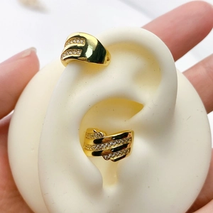 Detail of gold-plated wrap ear cuff with multi-row crystal rhinestones on a model ear