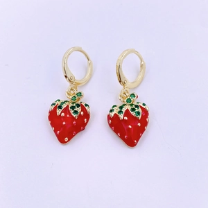 Dettaglio di orecchini a fragola rossi con strass verdi e metallo dorato lucido