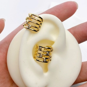 Detail einer goldfarbenen Mehrschicht-Ohrklemme mit Zirkonia auf einem weißen Ohrmodell