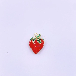 Dettaglio del ciondolo a fragola rossa con cristalli verdi e finitura dorata