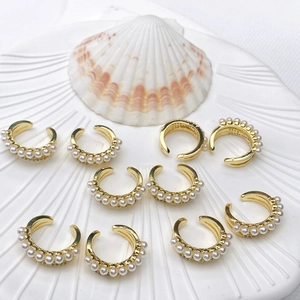 Detailed close-up of 18K gold plated C-shaped ear cuffs with elegant acrylic pearls