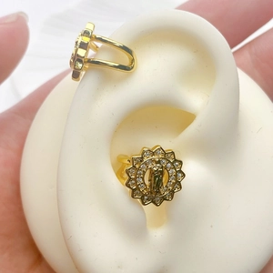 Detail view of gold-plated ear cuffs with Our Lady of Guadalupe and white zircons