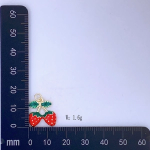 Dettaglio dell'orecchino a fragola rossa su scala graduata che mostra la misura 20 mm