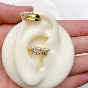 Close-up of gold ear cuff set featuring white pearls and cubic zirconia in a multi-layer design