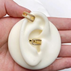 Detailed close-up of double-layered C-shaped gold ear cuff with white cubic zirconia stones