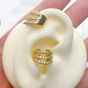 Macro detail of gold layered ear cuffs with pavé crystals on a silicone ear model