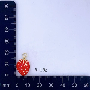 Dettaglio pendente a fragola rossa con scala graduata e peso indicato di 1,9 g