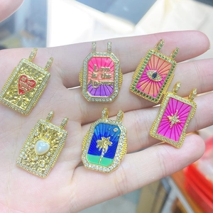 Detail of six gold-plated Bohemian tarot charms with zircons held by hand