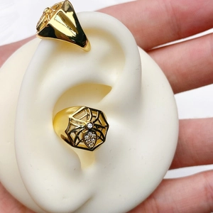Macro detail of 18K gold-plated C-shaped earrings with hexagon spider web and zircon inlay