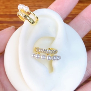 U-shaped gold ear cuff featuring small white pearls and shimmering pavé zircon stones