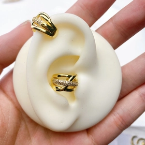 Close-up of gold-plated U-shaped ear cuffs with micro-pave cubic zirconia on an ear model