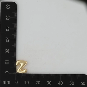 Detailed dimension measurement of a 3D gold-plated letter Z pendant with ruler