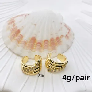 Detail eines 9mm vergoldeten Ohrmanschetten mit Zirkonia vor weißem Muschelhintergrund