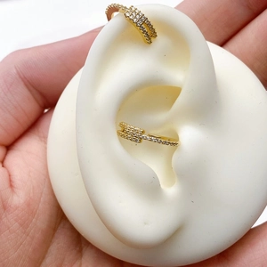 Close-up of gold-plated U-shaped ear cuffs with micro-pave cubic zirconia crystals