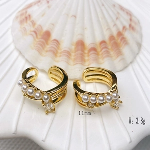 Macro view of double-layer C-shaped gold ear clips with white pearls and square zircon