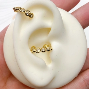 Close-up of French U-shaped gold ear cuff inlaid with sparkling cubic zirconia stones