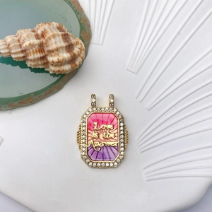 Macro detail of a rectangular gold-plated enamel pendant with micro-inlaid zircon and Love text