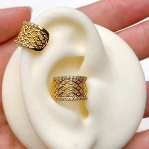 Close-up of gold-plated U-shaped ear cuffs with hollow lattice and sparkling zircons