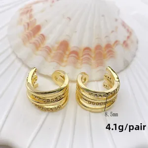 Detaillierte Makroansicht dreilagiger goldener Ohrmanschetten mit Zirkon-Inlay 8,5mm