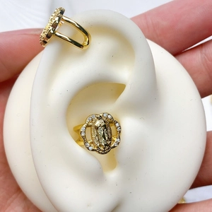 Macro shot of gold ear cuffs featuring Virgin Mary relief and sparkling rhinestones