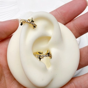 Detail of gold star-shaped ear cuffs with zircon pave setting on a display model