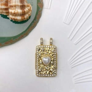 Detailed view of bohemian gold pendant with heart pearl and sparkling zircon frame