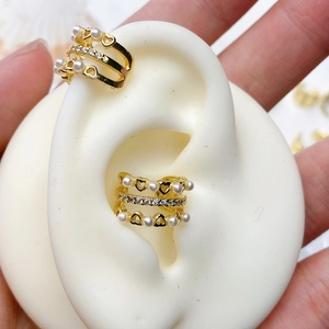 Macro shot of gold three-layer ear cuff with pearls and pavé cubic zirconia details